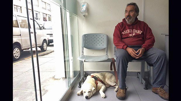 Jorge Velarde espera mientras su perro Pepito Machaguay es hidratado.