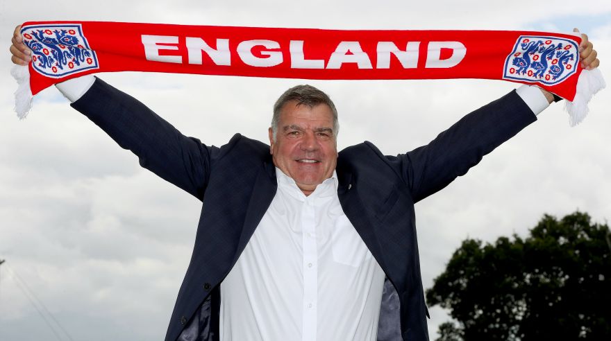 FILE- In this July 25, 2016 file photo, newly appointed England mangager displays an England scarf, in Burton-on-Trent, England. ?England manager Sam Allardyce has left his position after one match in charge of national team, it was reported on Tuesday, Sept. 27, 2016. (Martin Rickett/PA via AP, File)