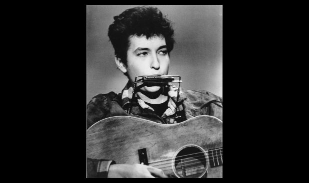 Marzo de 1963. Dylan tocando la armónica y su guitarra acústica. El lugar es desconocido. 