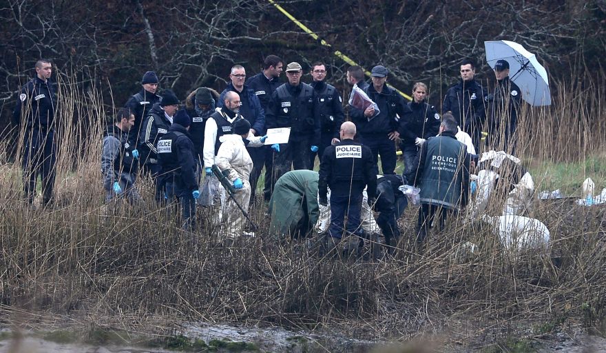 Police officers search on a swampy bank of the river Aulne near the Caouissin's house in Pont-de-Buis-l?s-Quimerch, western of France, on March 9, 2017. Investigators on March 8, found body parts at the home in northwest France of Hubert Caouissi, the man who has confessed to killing four relatives with a crowbar, the prosecutor in the case said. The mother of Pascal Troadec, one of the four victims of Hubert Caouissin, and that of Lydie, the companion of the supposed assassin, explains that the treasure discovered by her late husband is at the origin of the tragedy, in an interview with  French newpapers Le Parisien on March 9, 2017. / AFP / FRED TANNEAU
