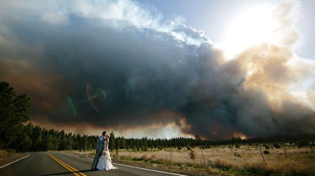 Pareja posa junto a un incendio forestal para sus fotos de boda